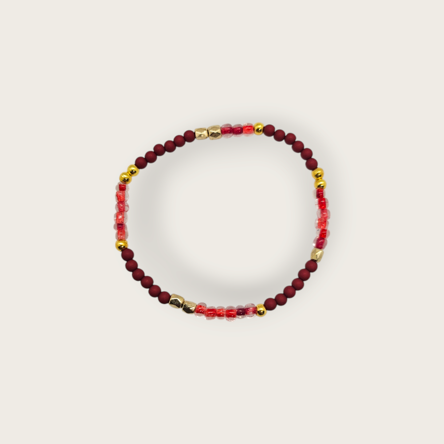 Elastieken armband met bordeaux rode kralen en gouden details