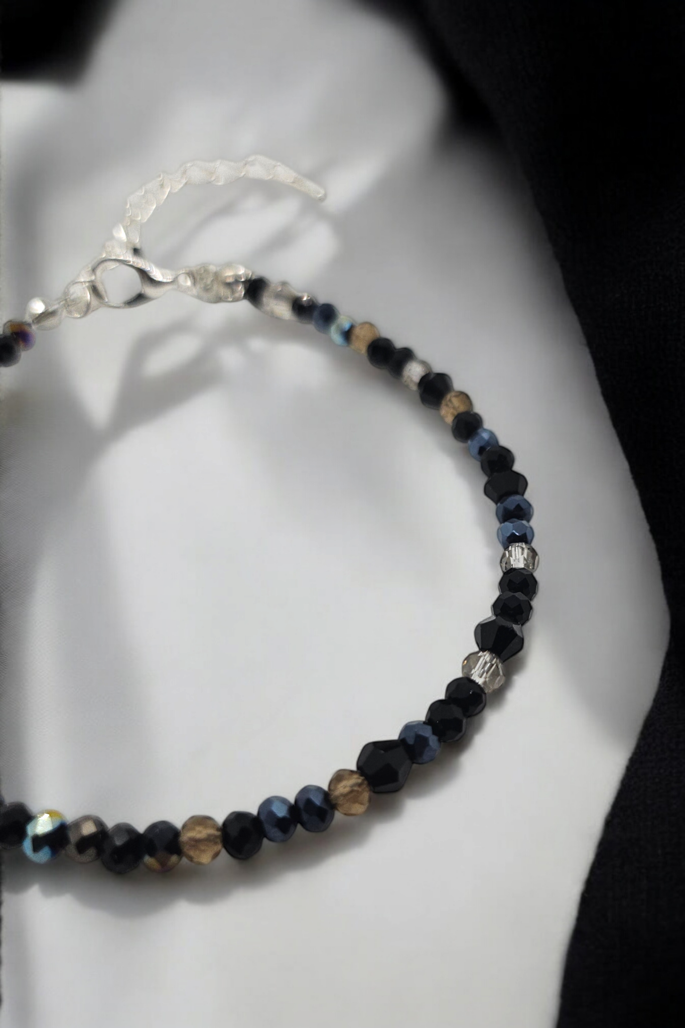 Armband met zwarte glaskralen en zilverkleurige sluiting