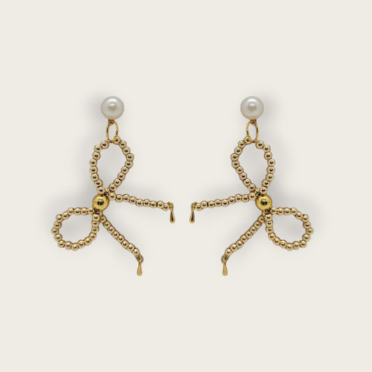 Goudkleurige oorbellen met gouden kralen strikvorm en namaak parel knopjes