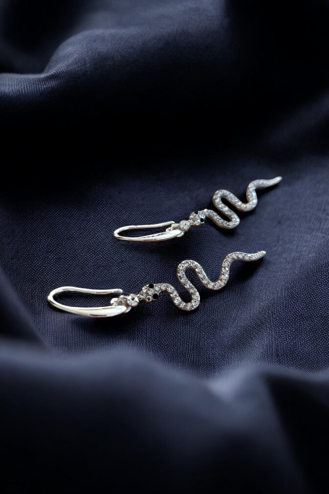 Zilveren oorhangers met een slangenvorm en glinsterende steentjes