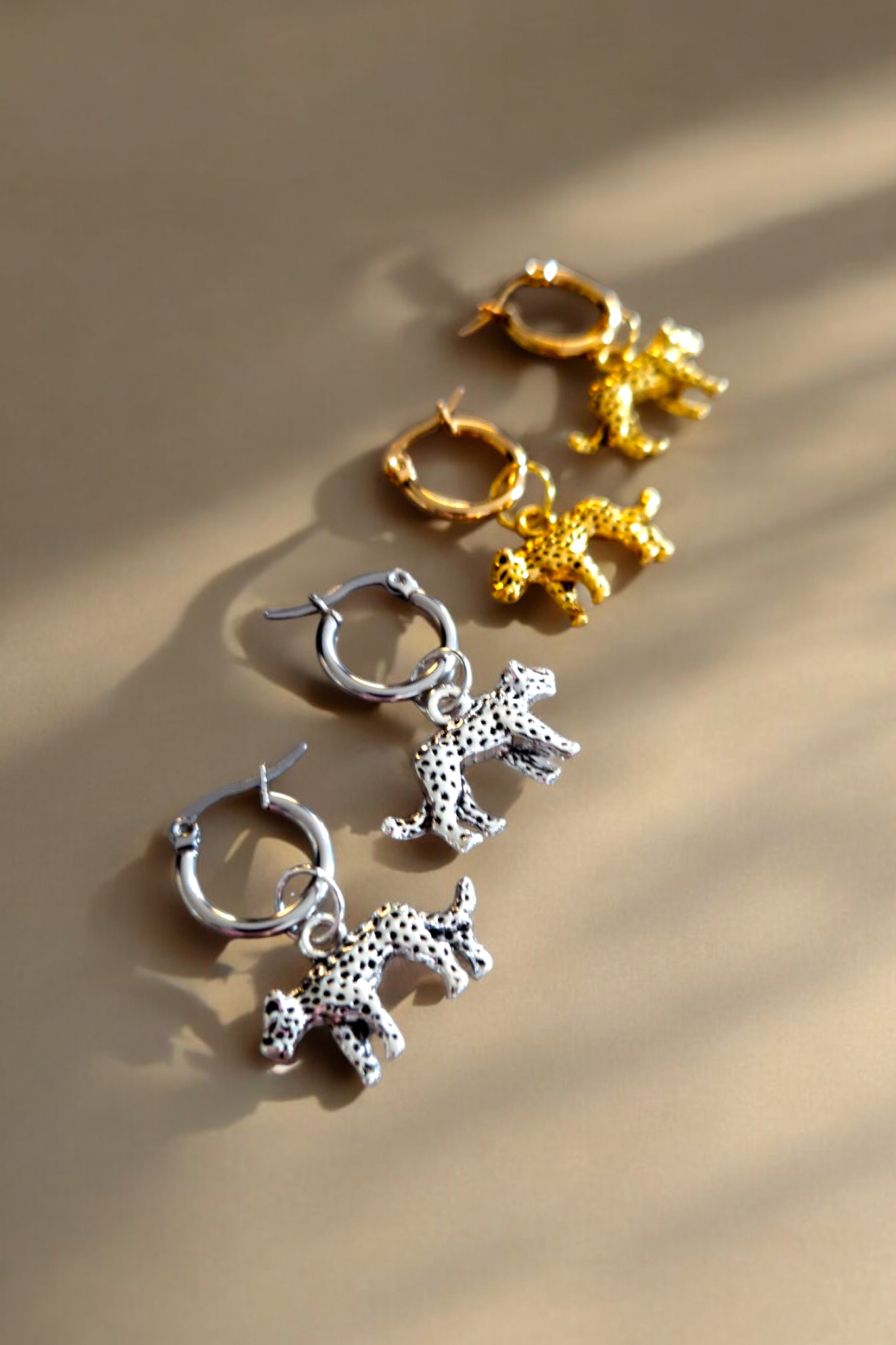 Gouden en zilveren oorringen met een panter hanger