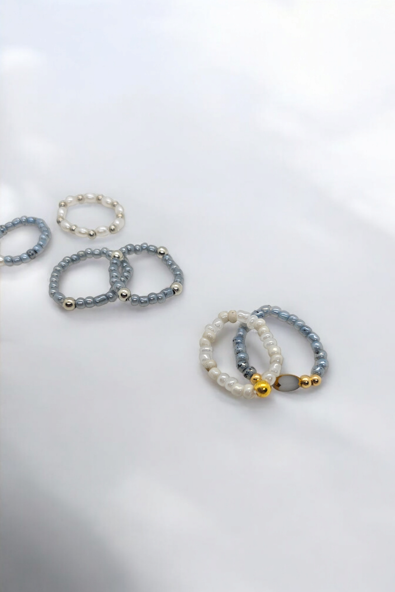 Elastieken ringen met blauwe en witte kralen en gouden en zilveren details one size