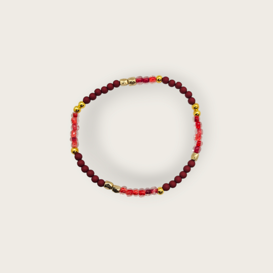 Elastieken armband met bordeaux rode kralen en gouden details