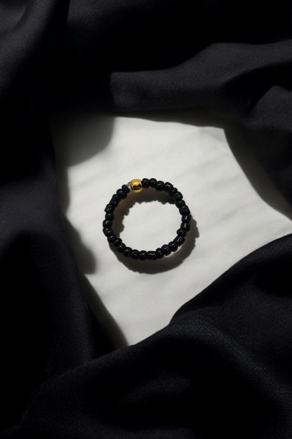 Zwarte elastieken ring met gouden kralen details one size
