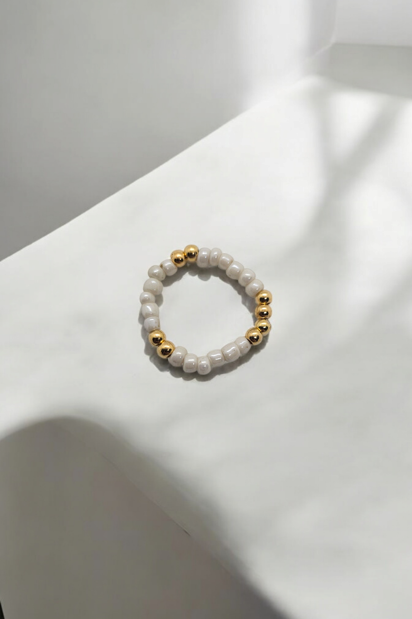 Witte elastieken ring met gouden kralen one size 